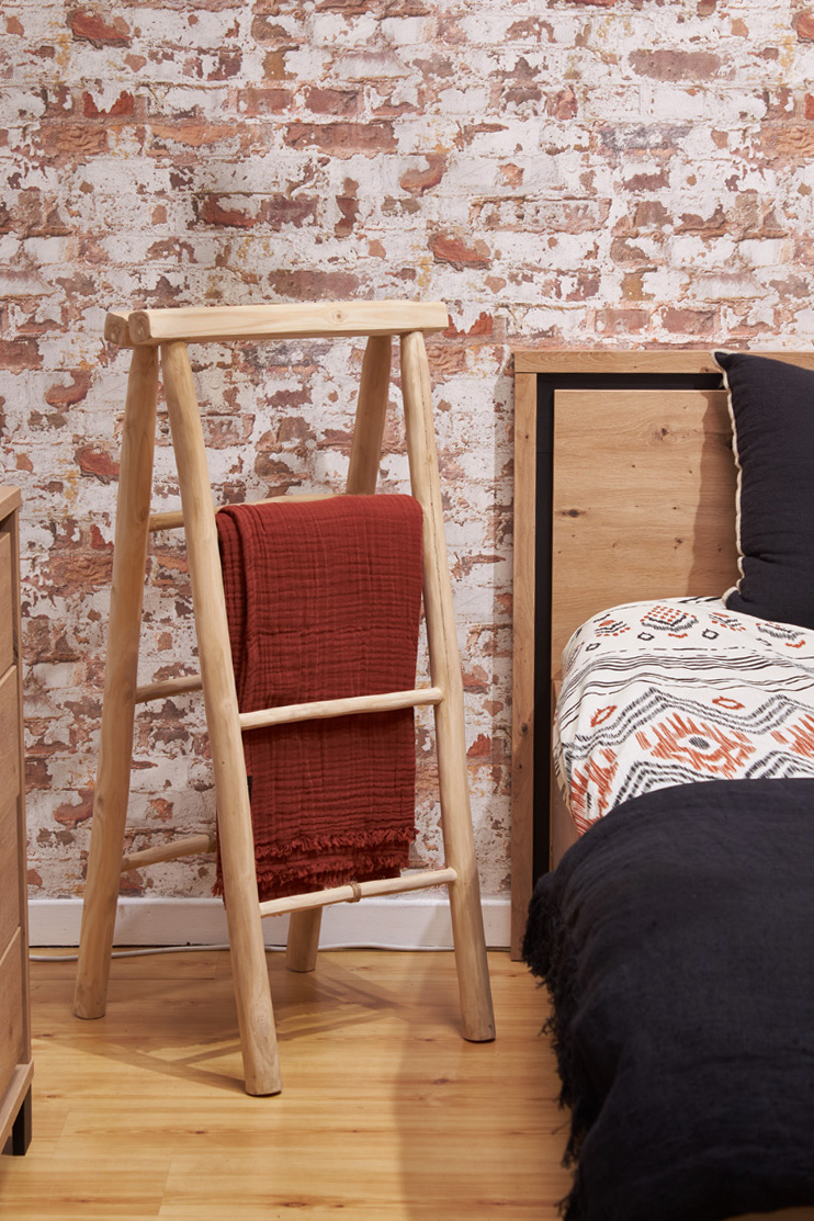 Photo au sein d'une chambre à coucher aux teintes écarlatates, avec un porte-serviette en bois de teck clair au style exotique.