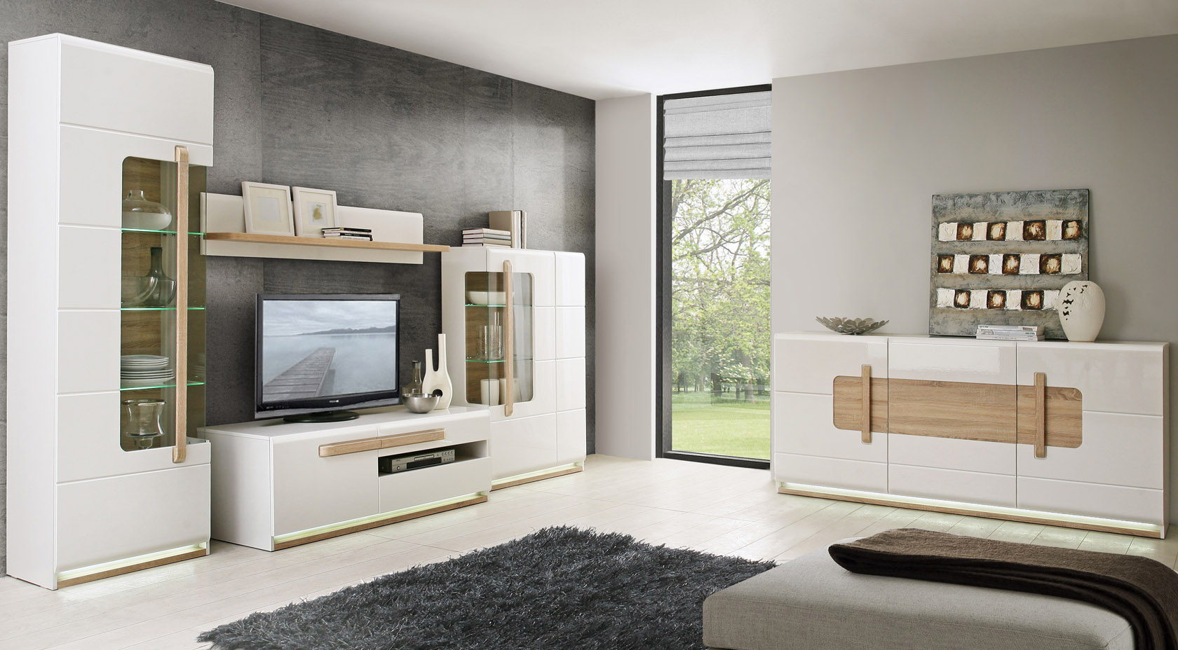 Un salon moderne et élégant, plein de vie et couleurs. Cette décoration met en avant les meubles de la collection ALEXIANE, orné d'un blanc laqué allié à un gris élégant ou un décor de bois clair.
