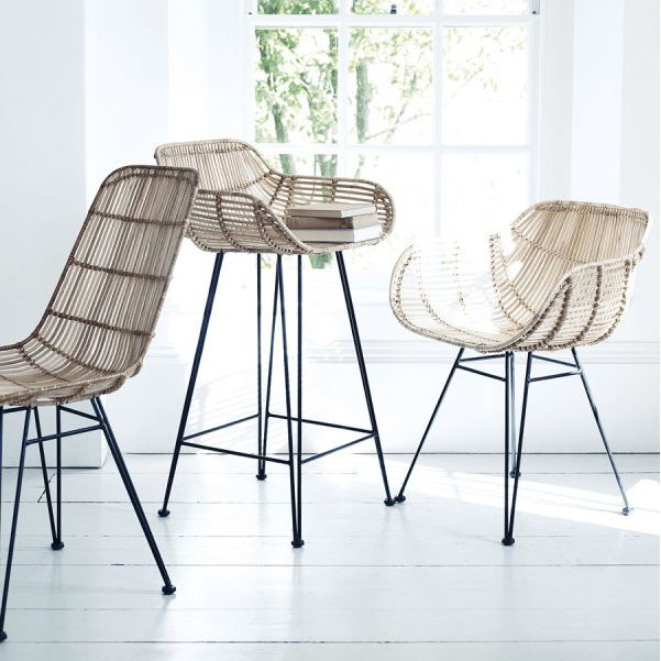 Image d'une pièce lumineuse qui met en avant trois types de siège différents, tous fabriquées en rotin. Sont présentés une chaise, un tabouret de bar et un fauteuil.