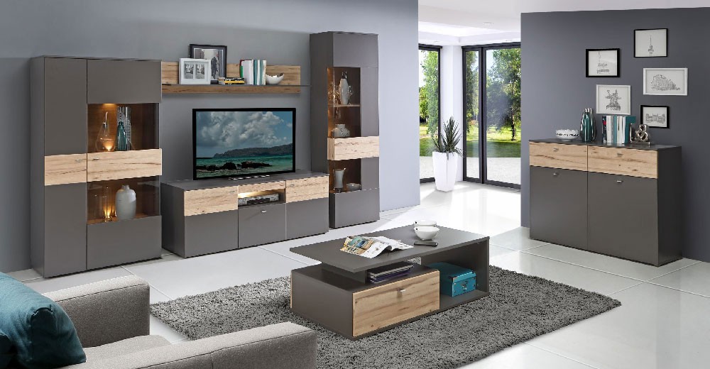 La collection MARBELLA, aux meubles décor bois clair et gris, présentée dans un salon moderne aux murs gris clair et au carrelage blanc. Sont présents sur l'image : l'armoire vitrée, le meuble TV, l'étagère murale, la colonne vitrée, le buffet et la table basse.
